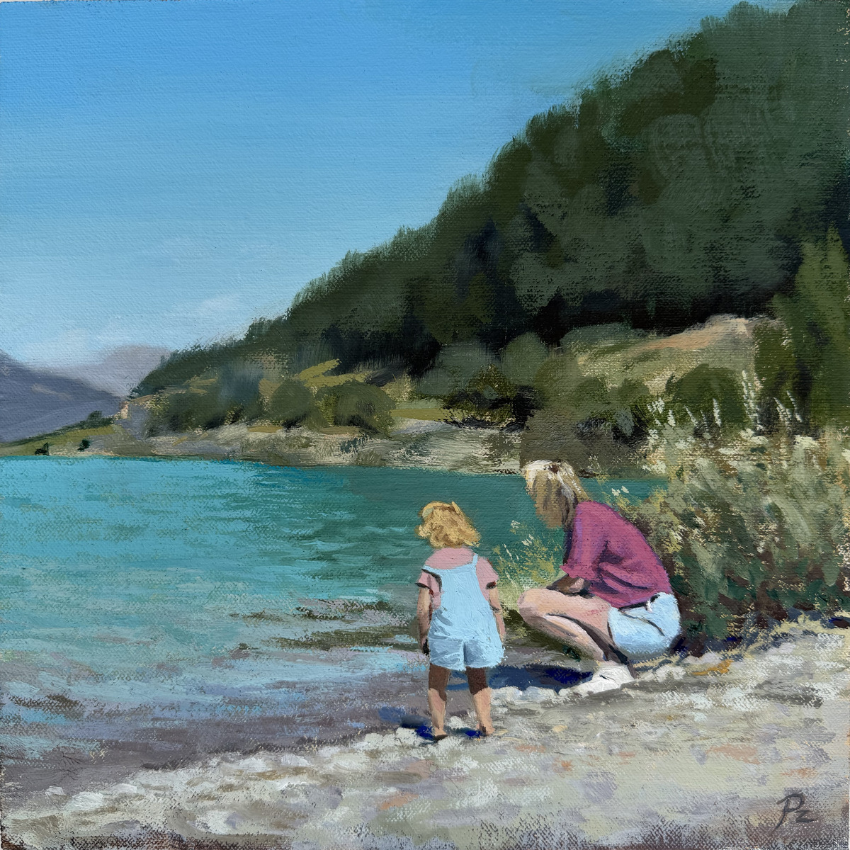 Moeder en dochter aan het turquoise water, met een beboste berg op de achtergrond.